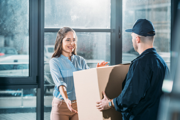 Woman receiving package from delivery man  - Photo, Image