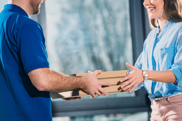 Woman receiving pizzas in boxes from delivery man  - Photo, Image