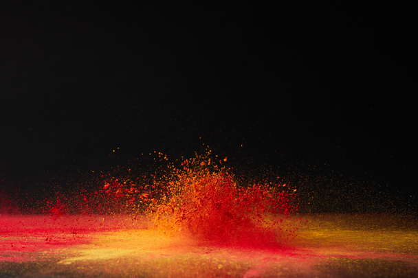 Oranje holi poeder explosie op zwart, hindoe Lentefestival - Foto, afbeelding