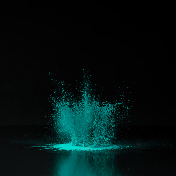green holi powder explosion on black, Indian festival of colours - Photo, Image
