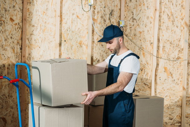 Delivery man stacking boxes on cart - Photo, Image