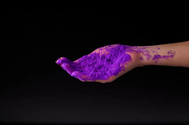 cropped view of hand with purple holi powder, isolated on black - Valokuva, kuva