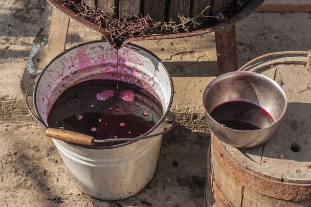 Виноробства. Технології виробництва вина. Народна традиція виготовлення вина. Виробництво вина в Молдові. Давні традиції переробки винограду. На Відкатавши використовується для преси вино. - Фото, зображення