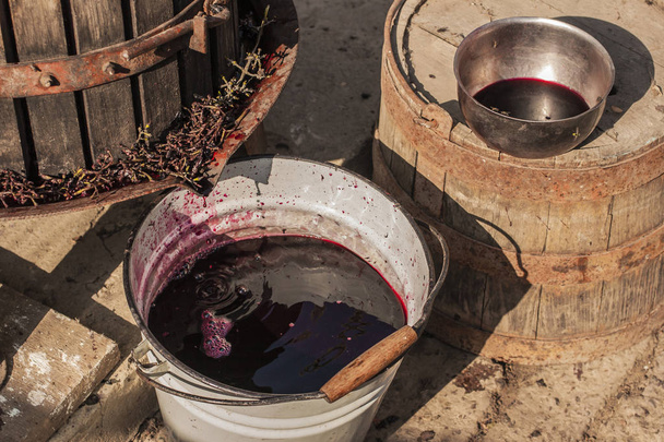 Elaboración de vino. Tecnología de producción de vino. La tradición popular de hacer vino. Producción de vino en Moldavia. La antigua tradición del procesamiento de la uva. El exprimidor se utiliza para presionar el vino
. - Foto, Imagen