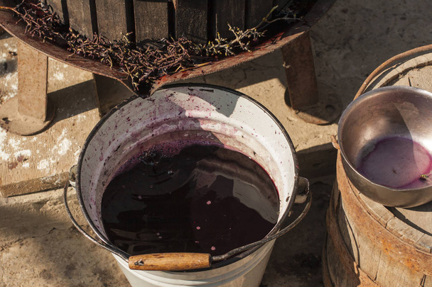 Elaboración de vino. Tecnología de producción de vino. La tradición popular de hacer vino. Producción de vino en Moldavia. La antigua tradición del procesamiento de la uva. El exprimidor se utiliza para presionar el vino
. - Foto, Imagen
