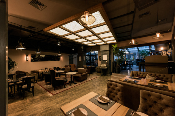 Blick auf stilvolles leeres Café mit arrangierten Tischen und Stühlen für Besucher - Foto, Bild