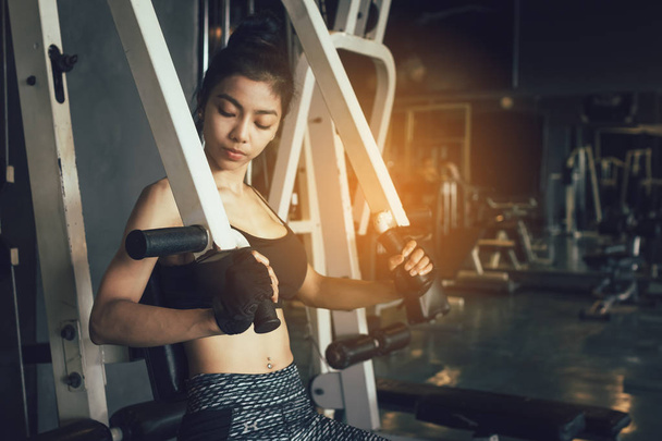 Asian women stronger and pushing weight bar at gym. - Photo, Image