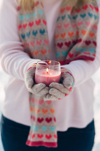 Young girl holds candle in hands in winter park - Fotoğraf, Görsel