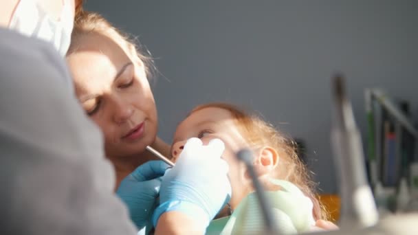 Κοπέλα για την υποδοχή στον οδοντίατρο, ο Στοματολόγος εξετάζει τα δόντια του παιδιού, άτακτο κορίτσι χαμογελά - Πλάνα, βίντεο