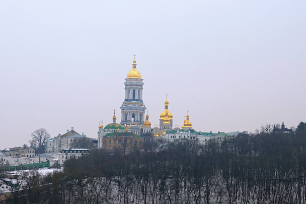 Kyievo-Pechers'ka lavra en klokkentoren op blauwe hemelachtergrond. Het is een historische orthodoxe christelijke klooster. Ochtend landschap foto. Mistige winterlandschap, Kiev, Oekraïne - Foto, afbeelding