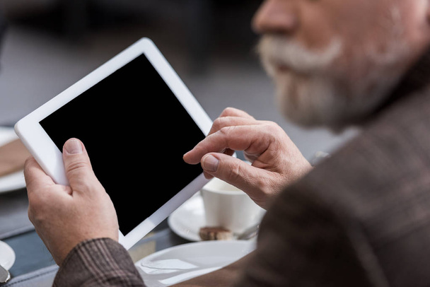 vista parcial de hombre de negocios con tableta con pantalla en blanco en la cafetería
 - Foto, imagen