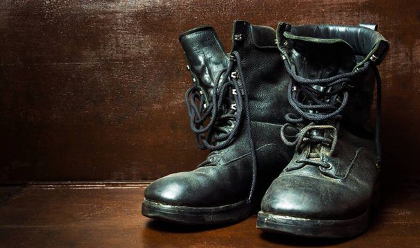 Old military boots against wooden background - Photo, Image