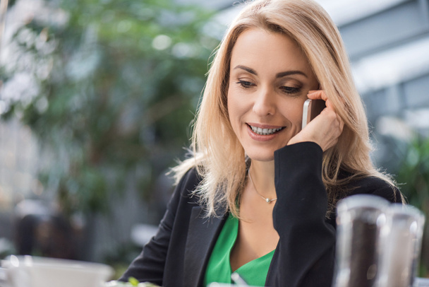 portrait of smiling businesswoman talking on smartphone  - Photo, image