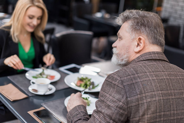 selective focus of senior man on romantic date with girlfriend in cafe - Photo, Image