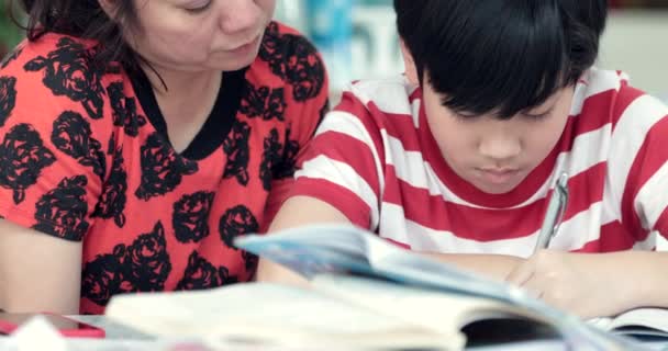 リビングで宿題の息子と深刻なアジアの母。お母さんが息子を教えている天才の作り方. - 映像、動画