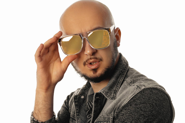 Adorable unshaved man in sunglasses posing on camera with opened - 写真・画像