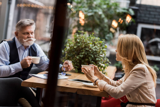 vista lateral dos empresários que têm reunião no café
 - Foto, Imagem