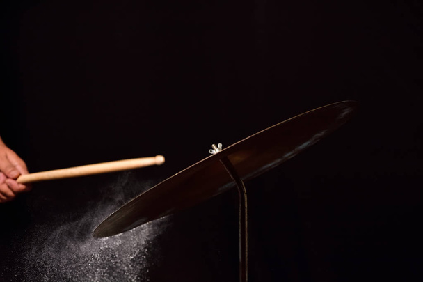 Muzikant raakt drum pallet op zwarte achtergrond - Foto, afbeelding