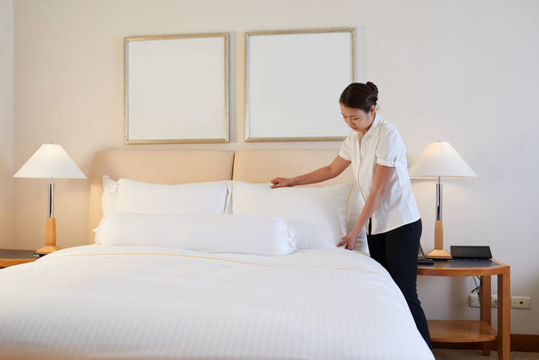 Empregada mudando de roupa no quarto de hotel
 - Foto, Imagem