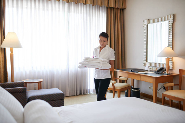Wietnamski młoda pokojówka, zmiana pościeli i ręczników w pokoju hotelowym - Zdjęcie, obraz