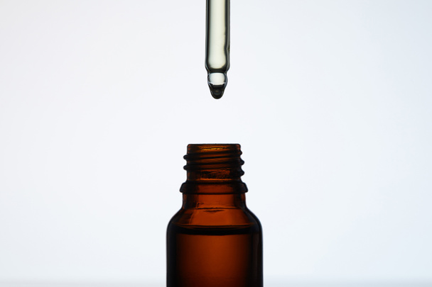 primer plano de la botella de aceite aromático con pipeta en blanco
 - Foto, Imagen