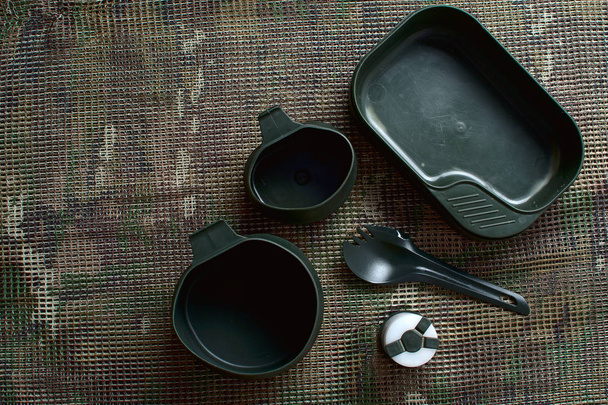 Set de vaisselle pour trekking repose sur un motif multicam backgro
 - Photo, image