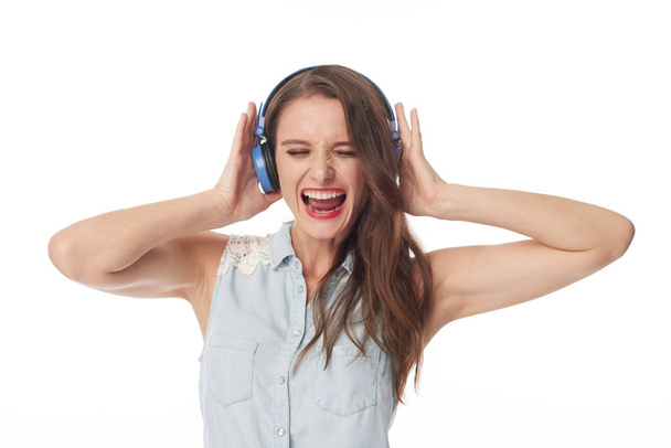 Excited young woman listening to her favorite music in her headphones - Photo, Image