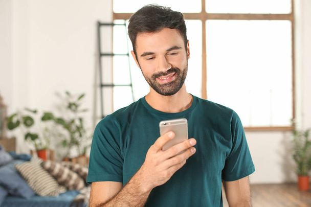 Young man using mobile phone indoors - Photo, Image