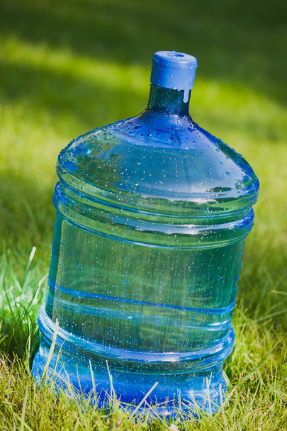 yeşil çim zemin üzerine büyük şişe su - Fotoğraf, Görsel