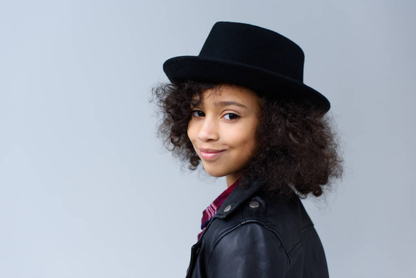 close-up portrait of little child with curly hair in hat isolated on grey - Photo, Image