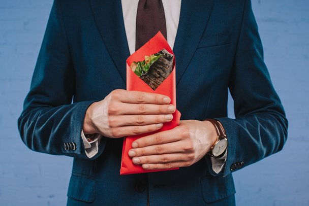 cropped shot of businessman in suit holding doner covered in red paper - Fotoğraf, Görsel