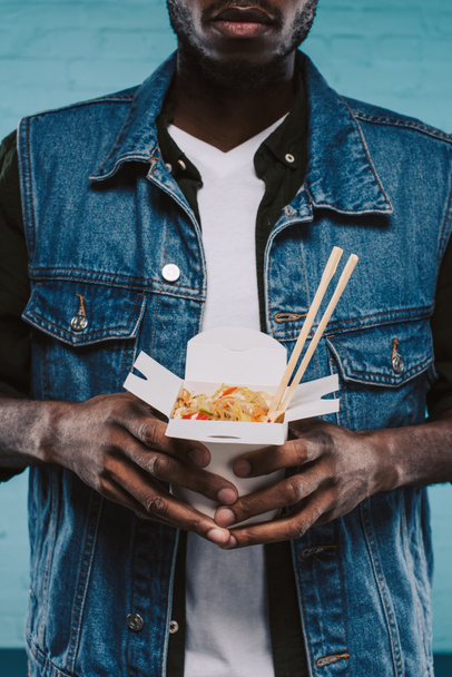 vágott lövés a stílusos afro-amerikai ember tartja be kínai tészta - Fotó, kép