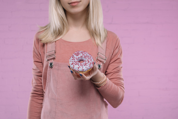 abgeschnittene Aufnahme einer Frau, die köstlichen glasierten Donut hält - Foto, Bild
