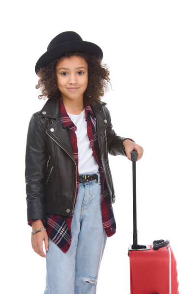 smiling little child with luggage looking at camera isolated on white - Foto, imagen