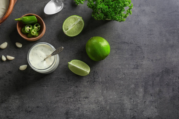 Tasty creamy lime sauce for fish taco in glass jar on kitchen table - Photo, Image