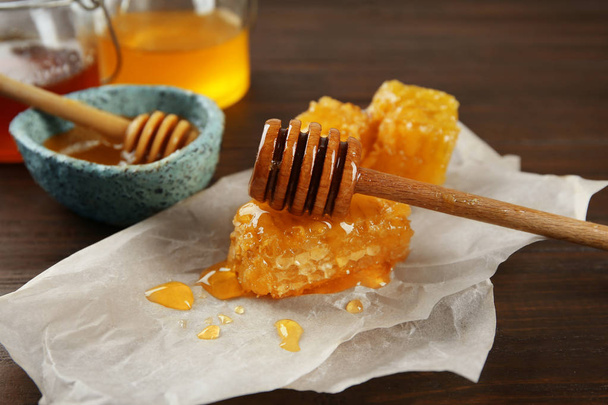 Sweet honeycombs and wooden dipper on table, closeup - Foto, Bild