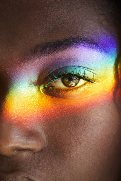 Rainbow light over eye of young african woman, closeup - Foto, Bild