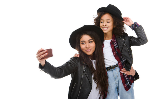 stylish mother and daughter taking selfie with smartphone isolated on white - Photo, Image