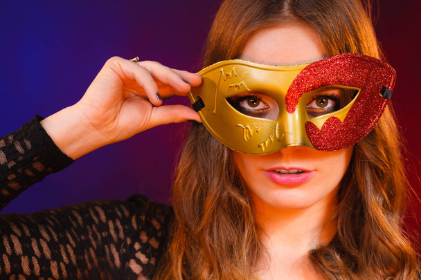 Closeup woman face with carnival golden red mask on dark - Photo, image