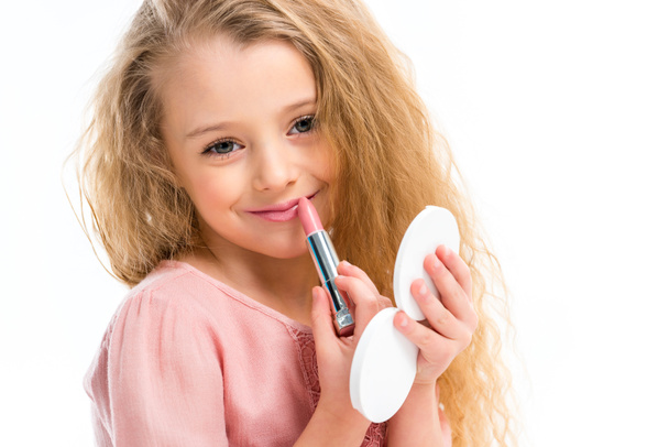 Portrait of smiling child doing makeup by pink lipstick isolated on white - Fotografie, Obrázek