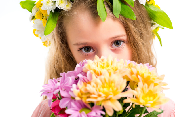 Closeup view of kid wearing wreath band and holding bouquet of flowers isolated on white - Foto, immagini