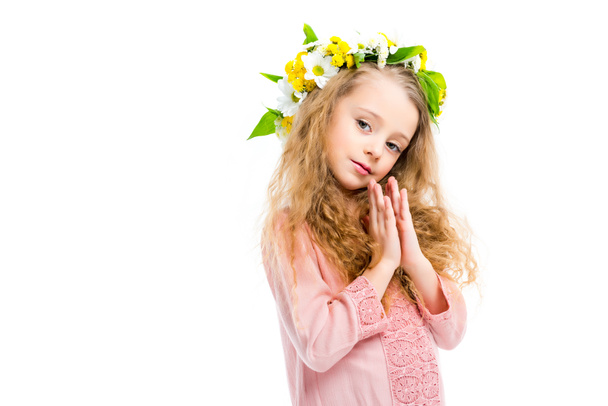 Little child holding handbreadths together and wearing wreath band from flowers isolated on white - Valokuva, kuva