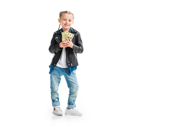 Happy little kid in leather jacket holding banknotes isolated on white - Foto, afbeelding