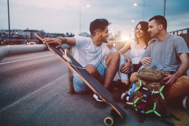 Group of happy friends hang out together carrying skateboards - Zdjęcie, obraz