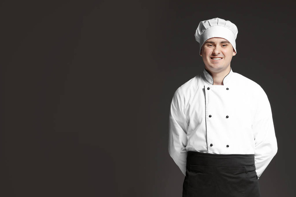 Male chef in uniform on dark background - Foto, imagen