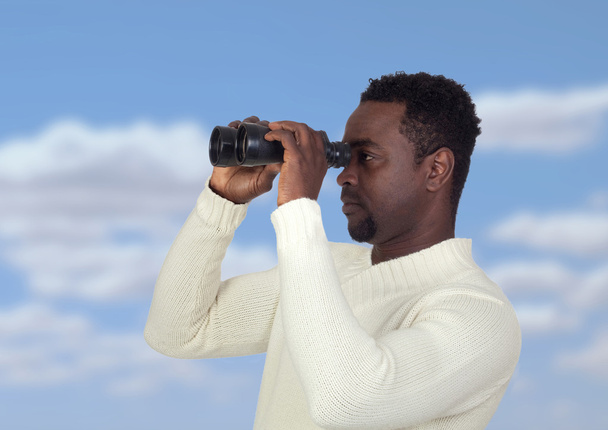 Attrayant homme africain regardant à travers les jumelles
 - Photo, image