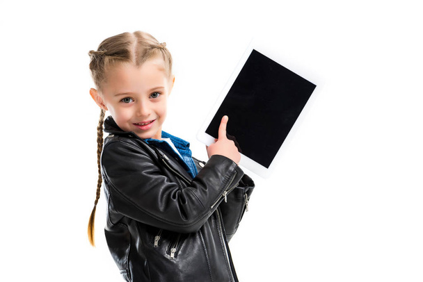 Portrait of stylish child with pigtails pointing at screen of digital device isolated on white - 写真・画像