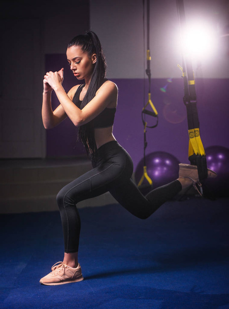 Спортивная женщина делает TRX упражнения в тренажерном зале
 - Фото, изображение