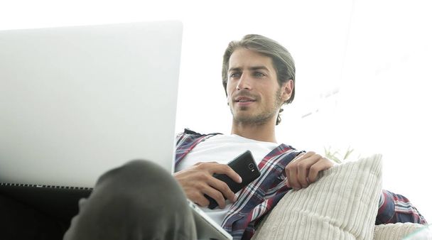 successful guy sitting on sofa in living room - Foto, imagen