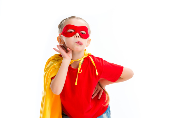 Supergirl wearing yellow cape and red mask for eyes showing tongue isolated on white - Zdjęcie, obraz